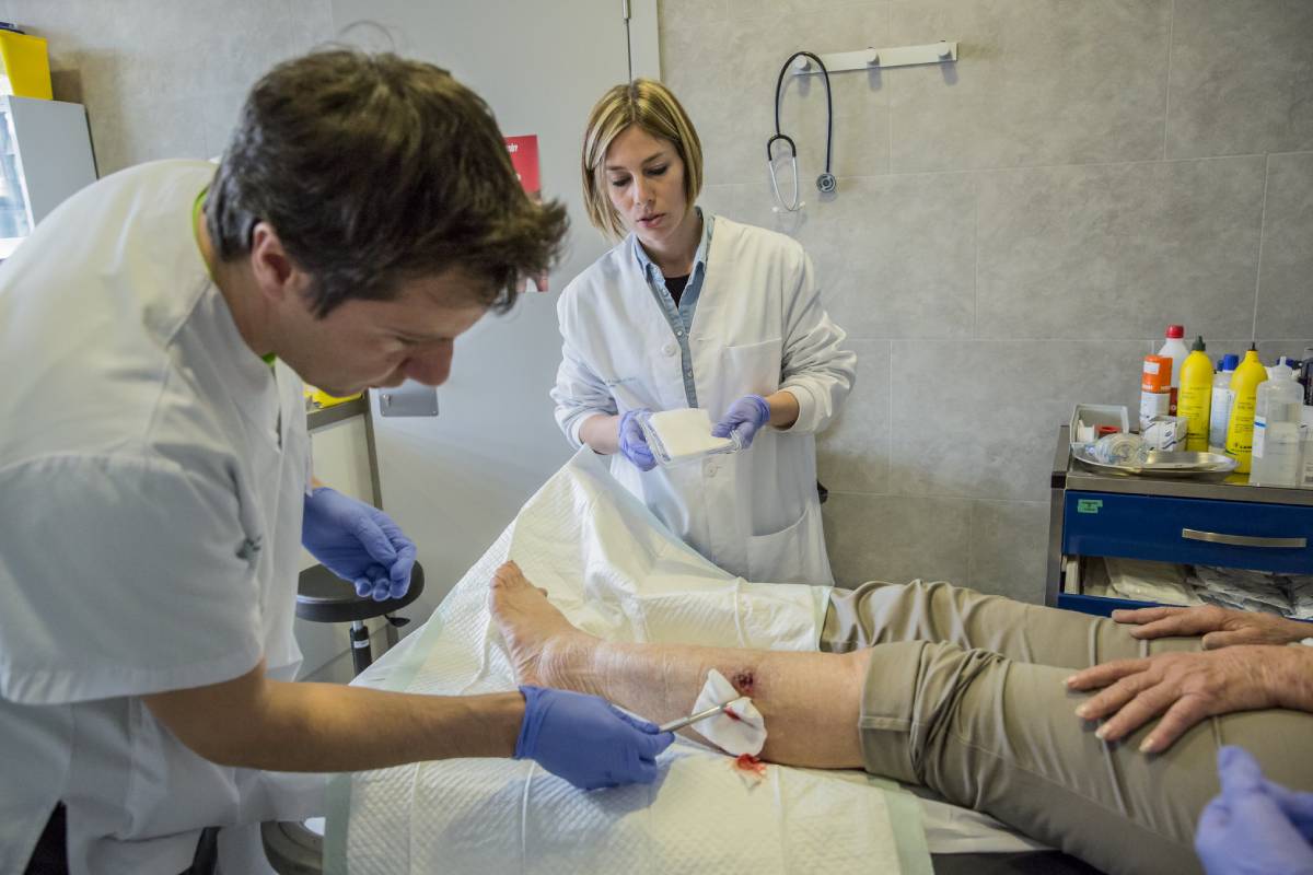 Un enfermero curando una herida. FOTO: Ariadna Creus y Àngel García (Banc Imatges Infermeres).